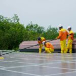 A team of workers cleaning solar panels on a sunny day, focusing on renewable energy maintenance.